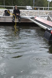 The diver has gone under water and bubbles rise to the surface.