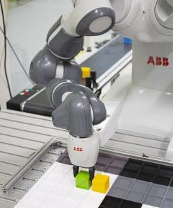 ABB-robotti on ohjelmoitu siirtelemään palikoita.