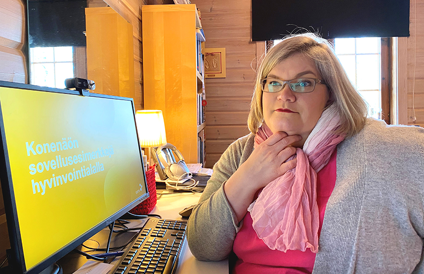 Kuvassa Mirka Leino istuu työpisteensä ääressä kotitoimistolla.