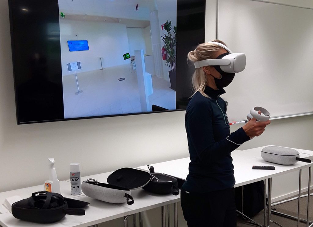 Nainen käyttää VR-laseja. Taustalla näytössä lasien kuva.