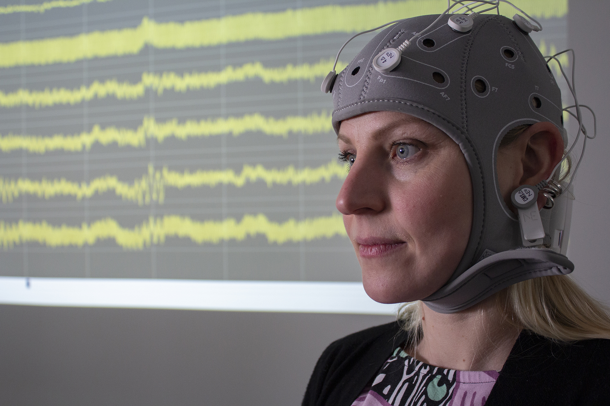 Closeup of a woman with a EEG hat on.
