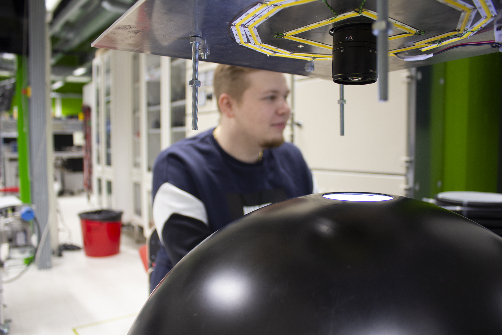 Close-up with machine vision camera, student in the background.