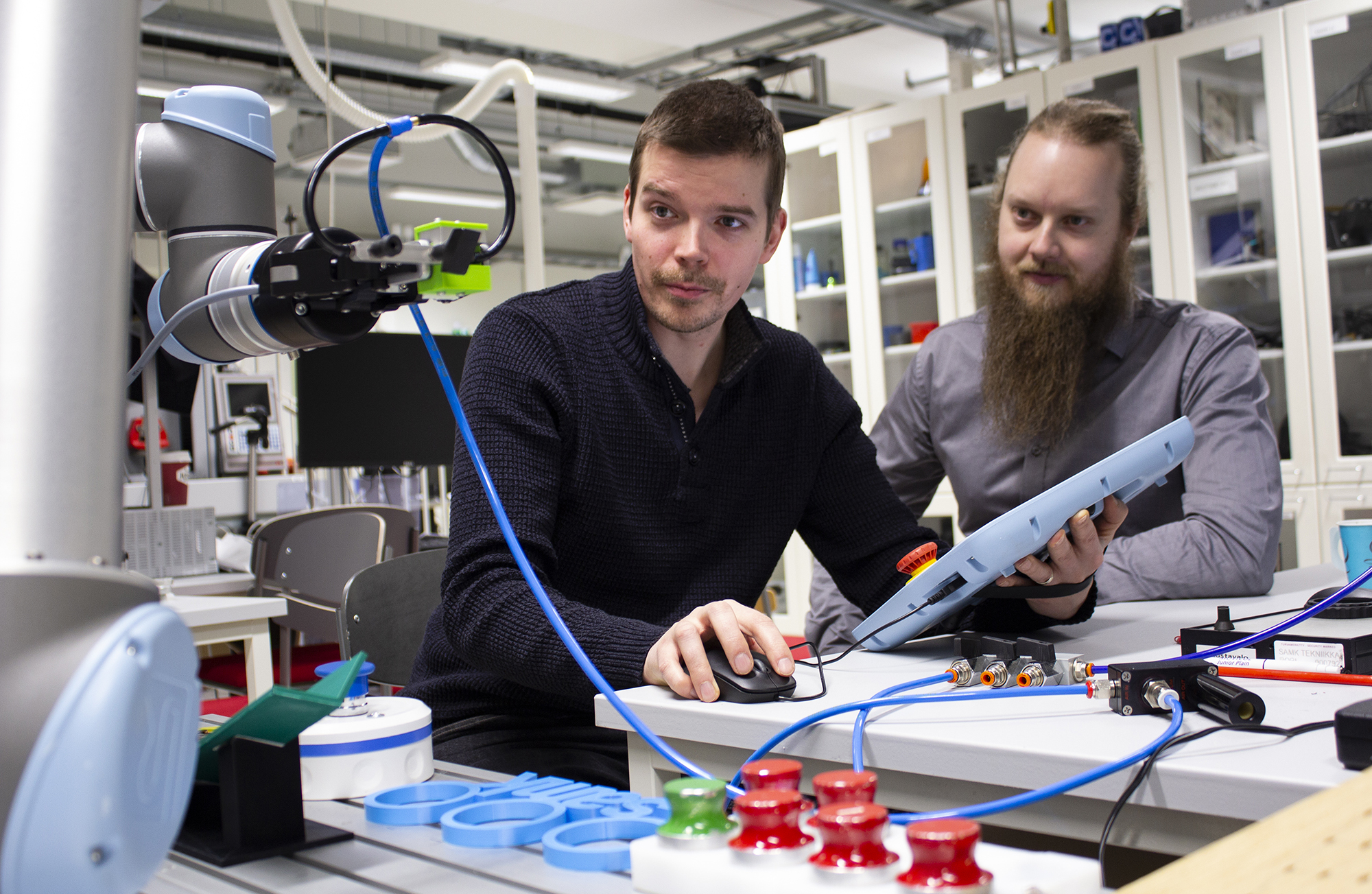 In the picture two men are using the TM robot.