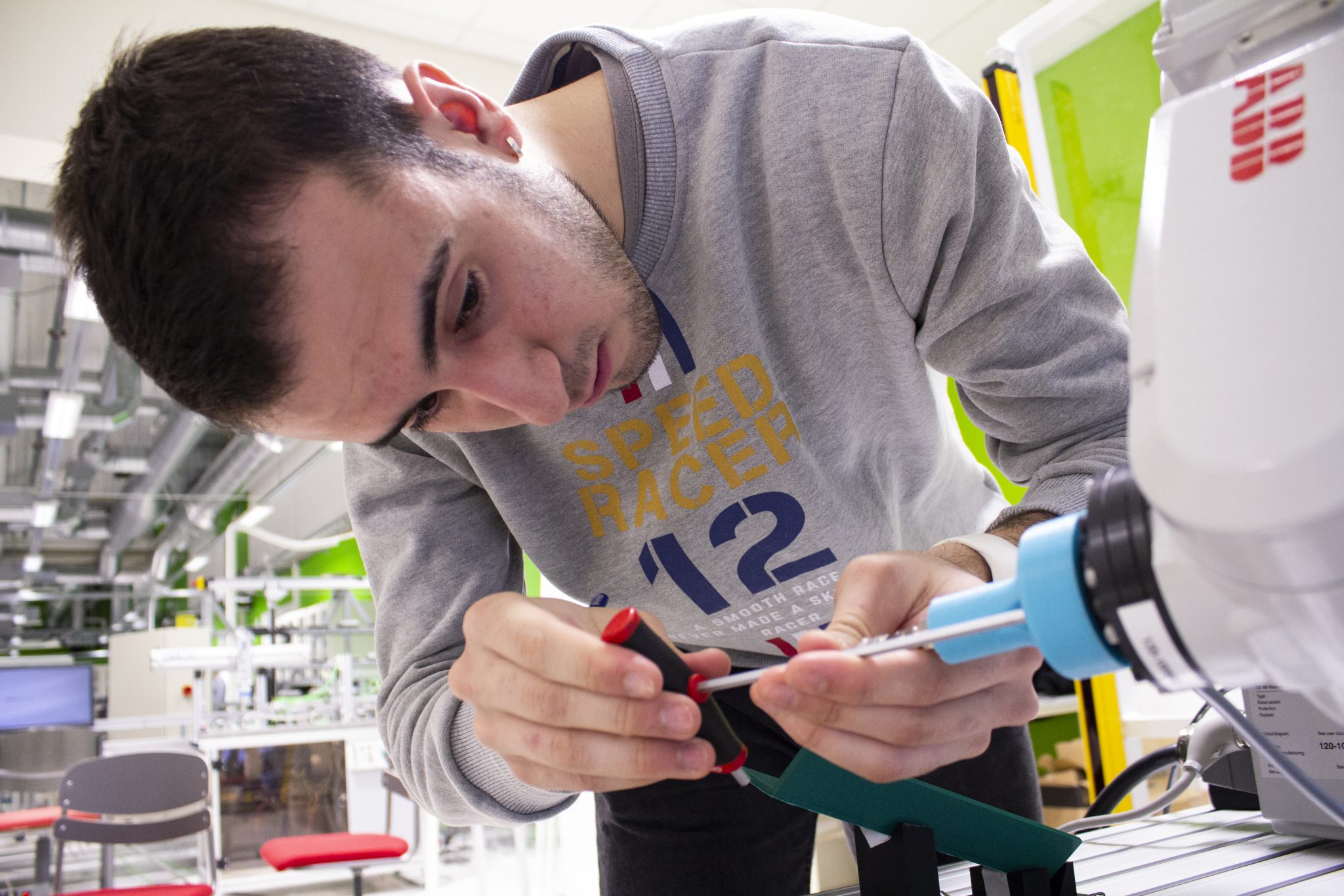 Jaime Kasvottarkat A young man screws something into a robot.