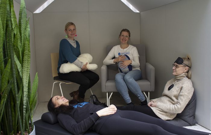 Kuvassa neljä naista testaa rentoutumista hyvinvointiteknologisin keinoin.