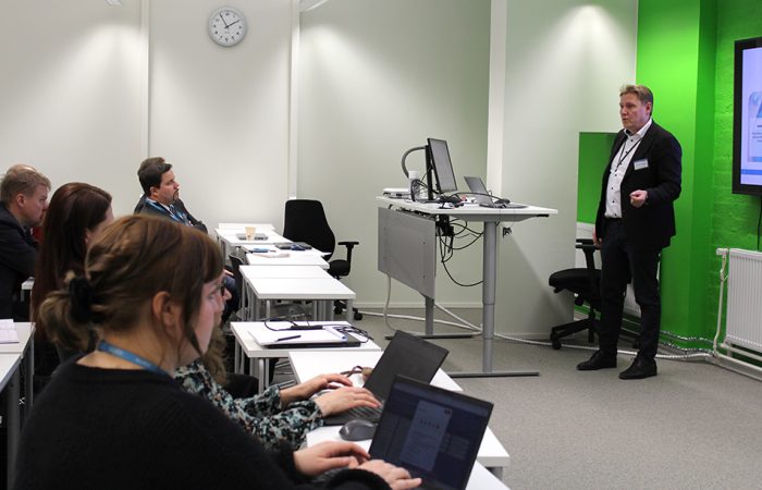 Mies puhuu yleisön edessä.