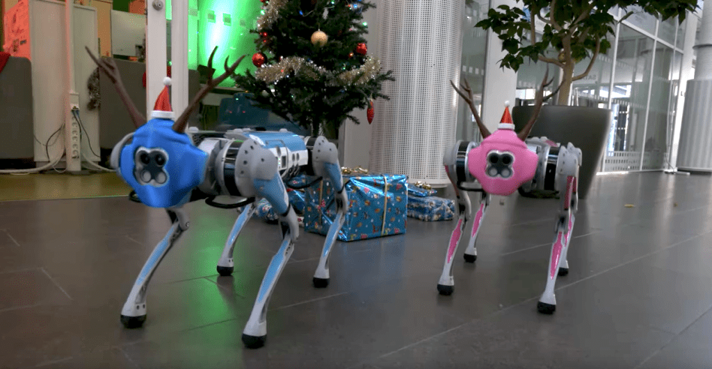 Kaksi robottikoiraa, joilla on jouluisia koristeita.