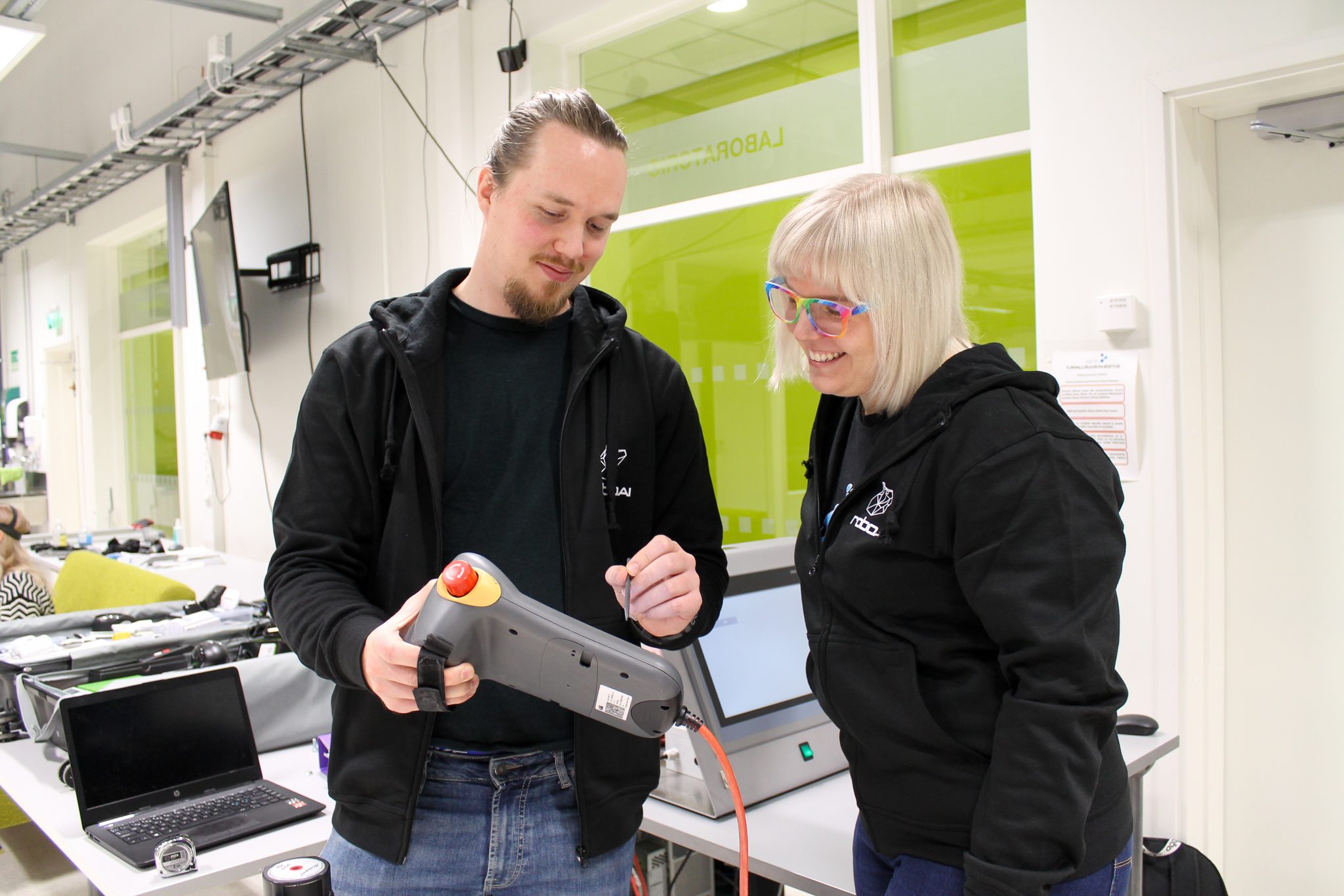 Two students are looking at the robot controller.