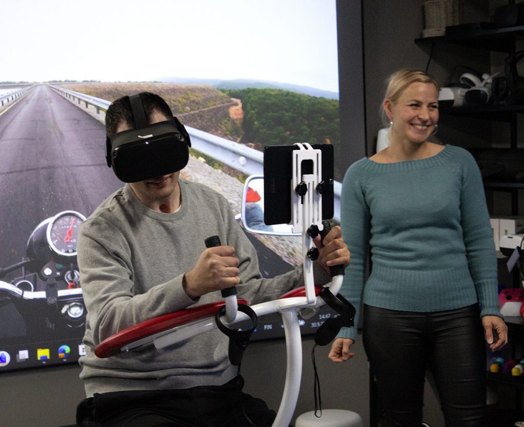 A man rides a motorbike in a gaming chair with VR glasses.