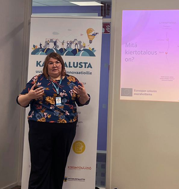 Naishenkilö puhuu tilaisuudessa.