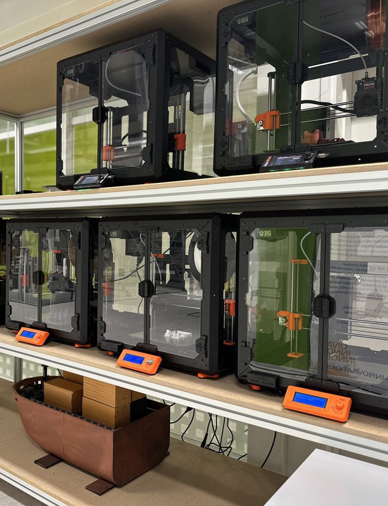 There are 3D printers on the shelf.