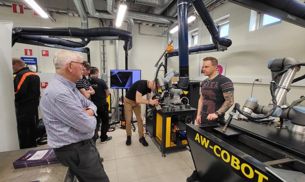 Henkilöitä tutustumassa yhteistyörobotteihin