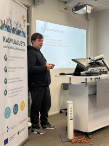 Mieshenkilö puhuu tilaisuudessa.