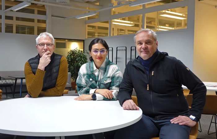 Tarmo Lipping, Reijo Koivula ja Matin Beiramvand istuvat valkoisen pöydän ääressä ja katsovat kameraan.