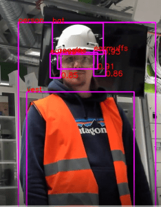 Kuvakaappaus konenäköohjelmasta, henkilö jolla turvavarusteita päällä