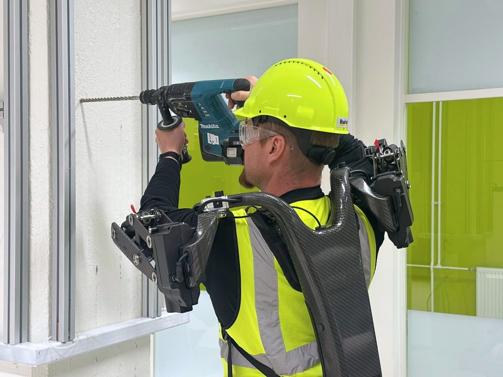 A man holding a heavy drill dressed in exoskeleton