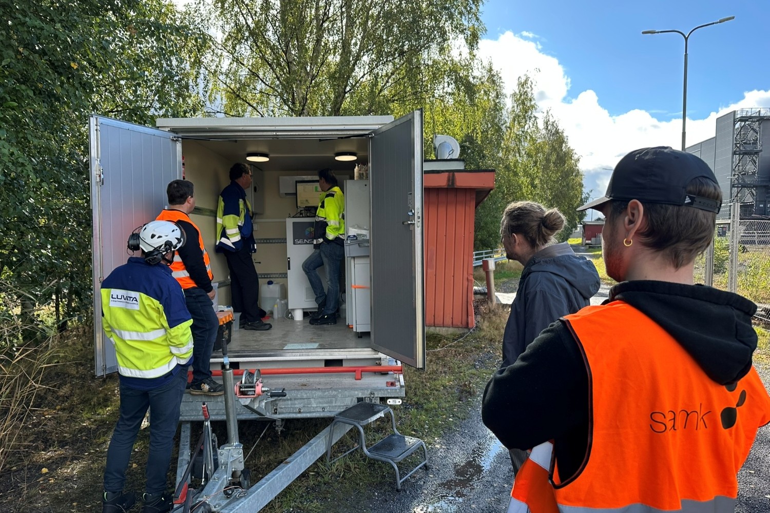 ROSS Demopäivä 2 Henkilöitä seisomassa mittauskontin sisällä ja sen ulkopuolella.