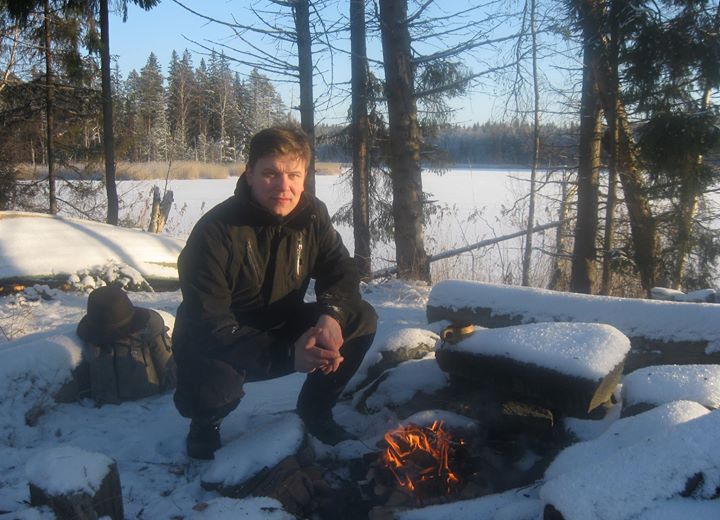 Lähikuvassa Timo Santa-Nokki, joka on luonnossa nuotiopaikalla.