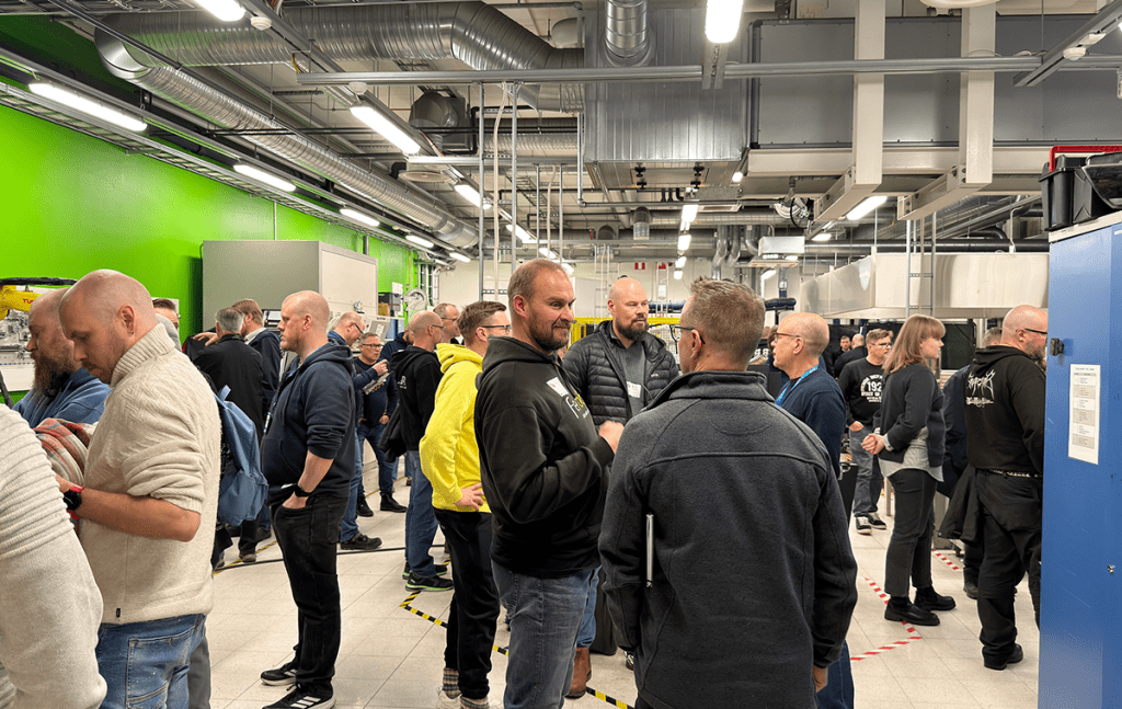 Yleiskuva tilasta, jossa suuri joukko ihmmisiä, jotka keskustelevat keskenään.