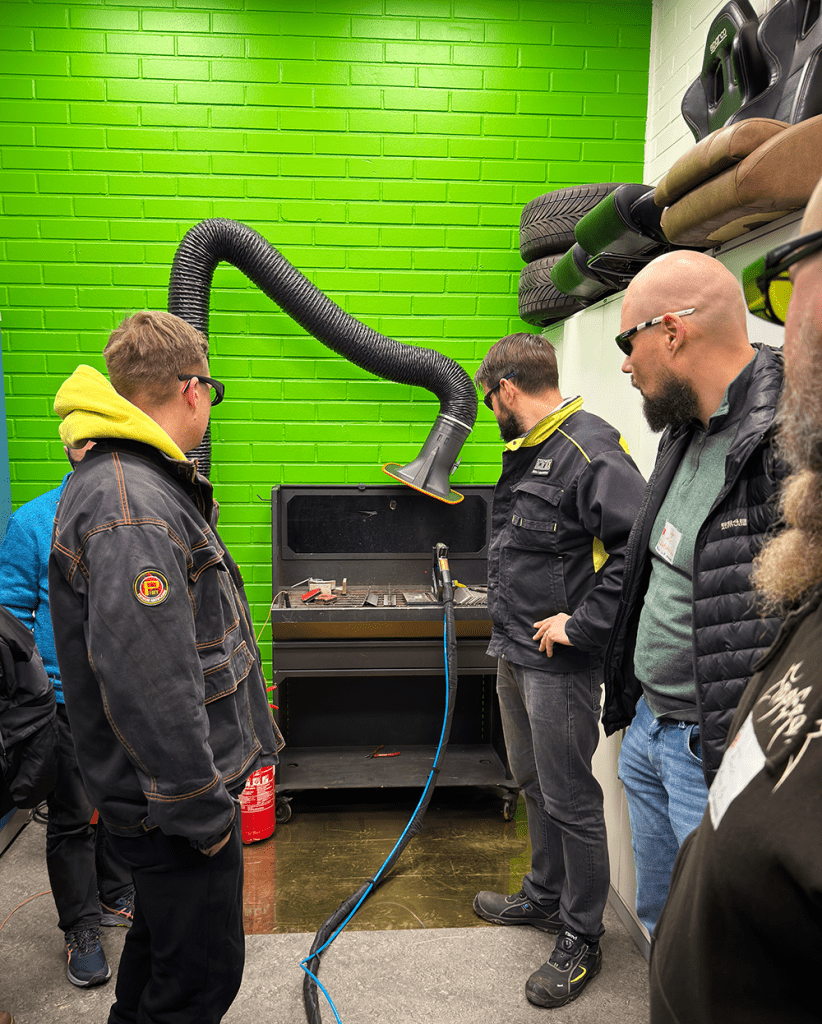 Mieshenkilö esittelee laserhitsausvälineitä.