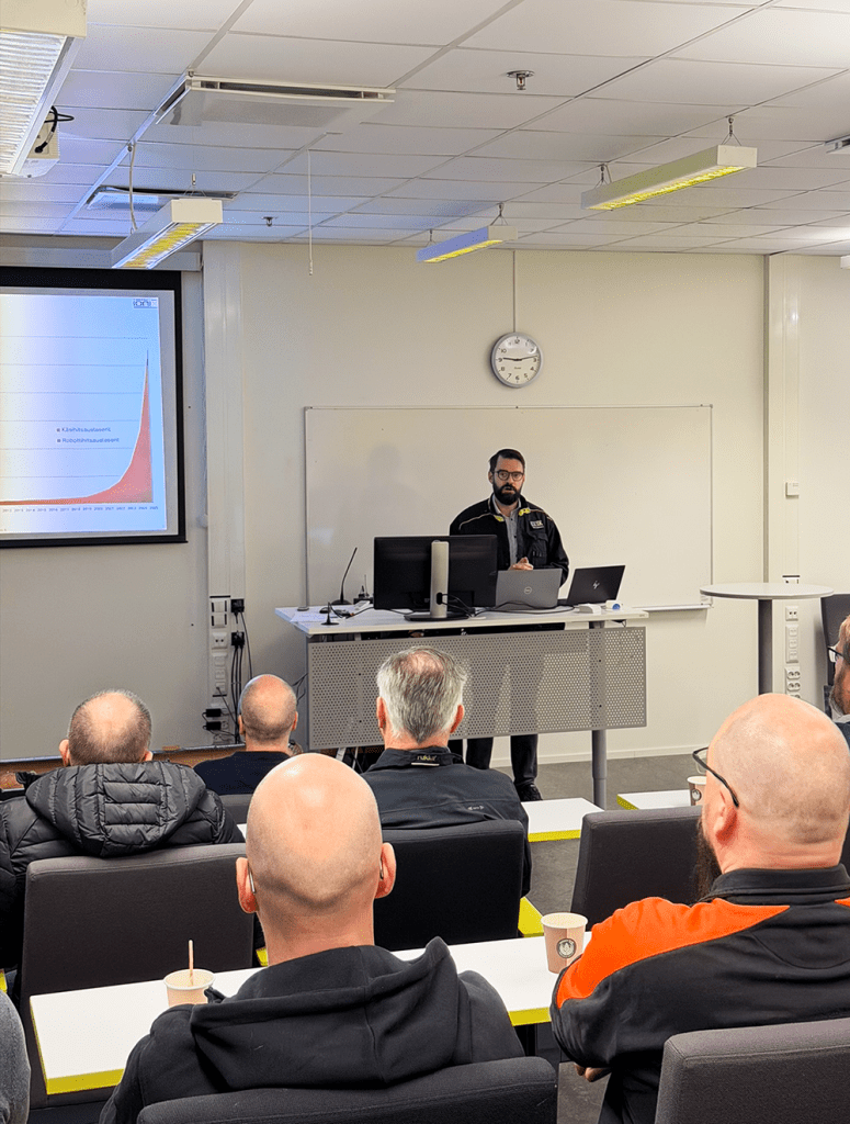 Mieshenkilö puhuu auditoriossa.