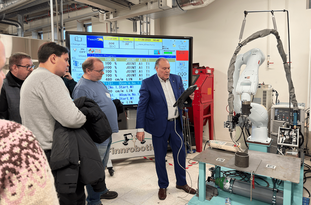 Mieshenkilö esittelee robottihitsauslaitteen toimintaa.