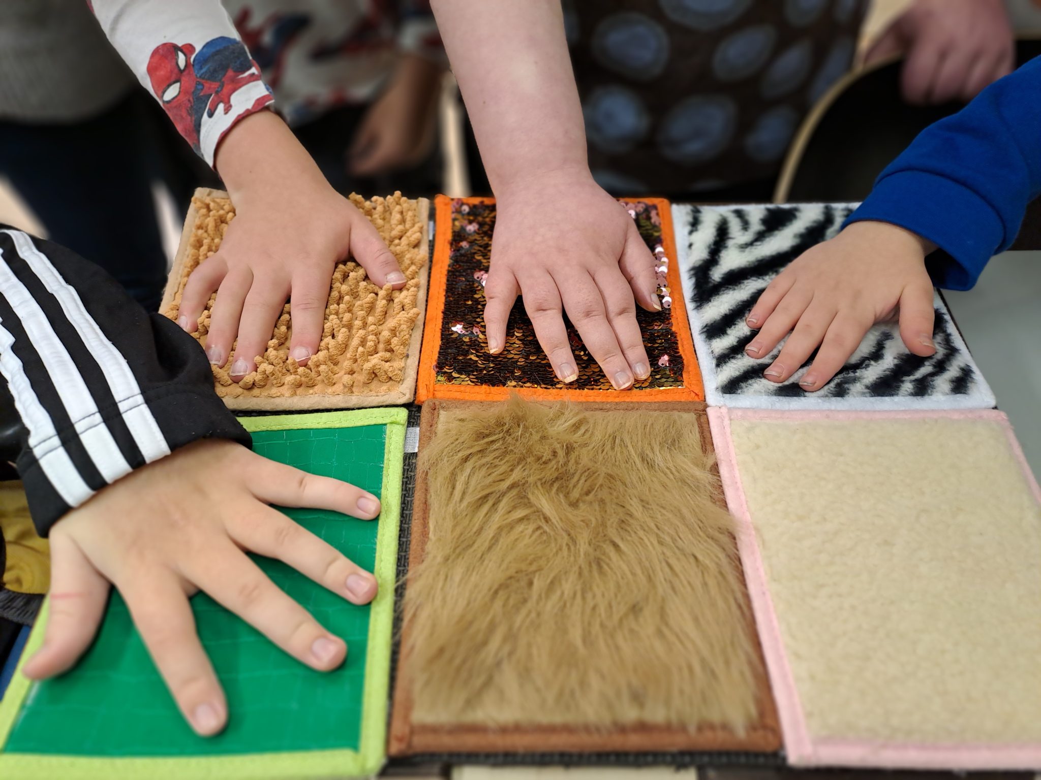 The picture shows different surfaces that children's hands can explore.