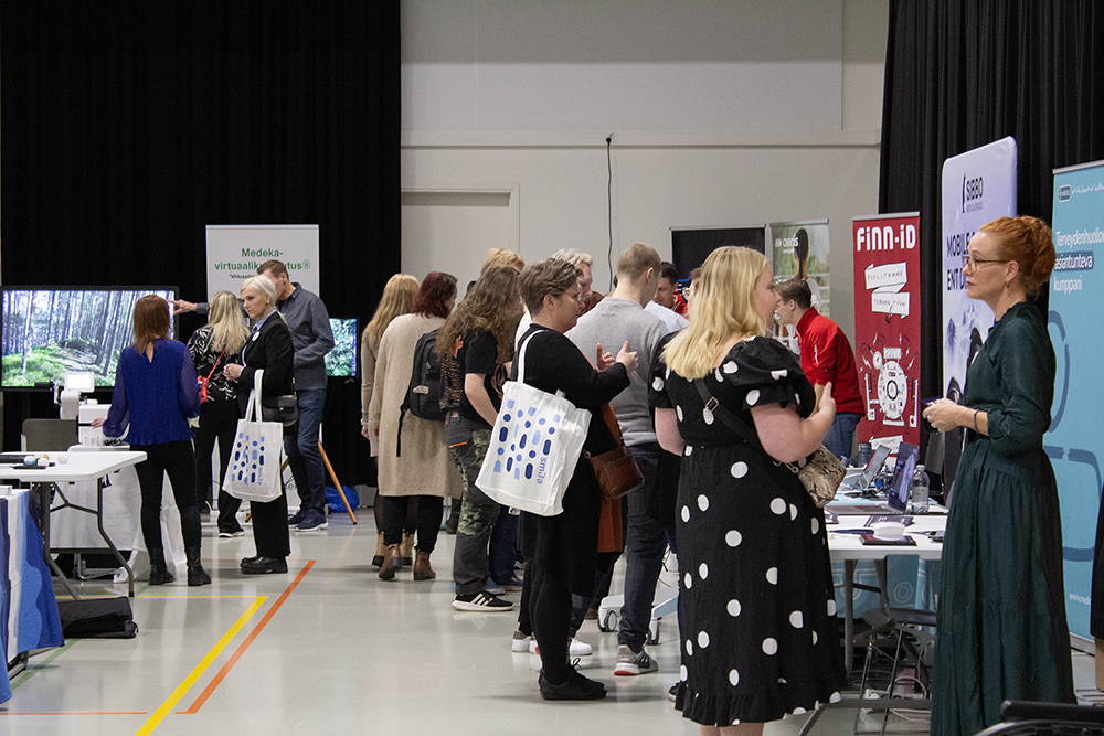 Kuvassa on henkilöitä hyvinvointiteknologiamessuilla vuonna 2024.