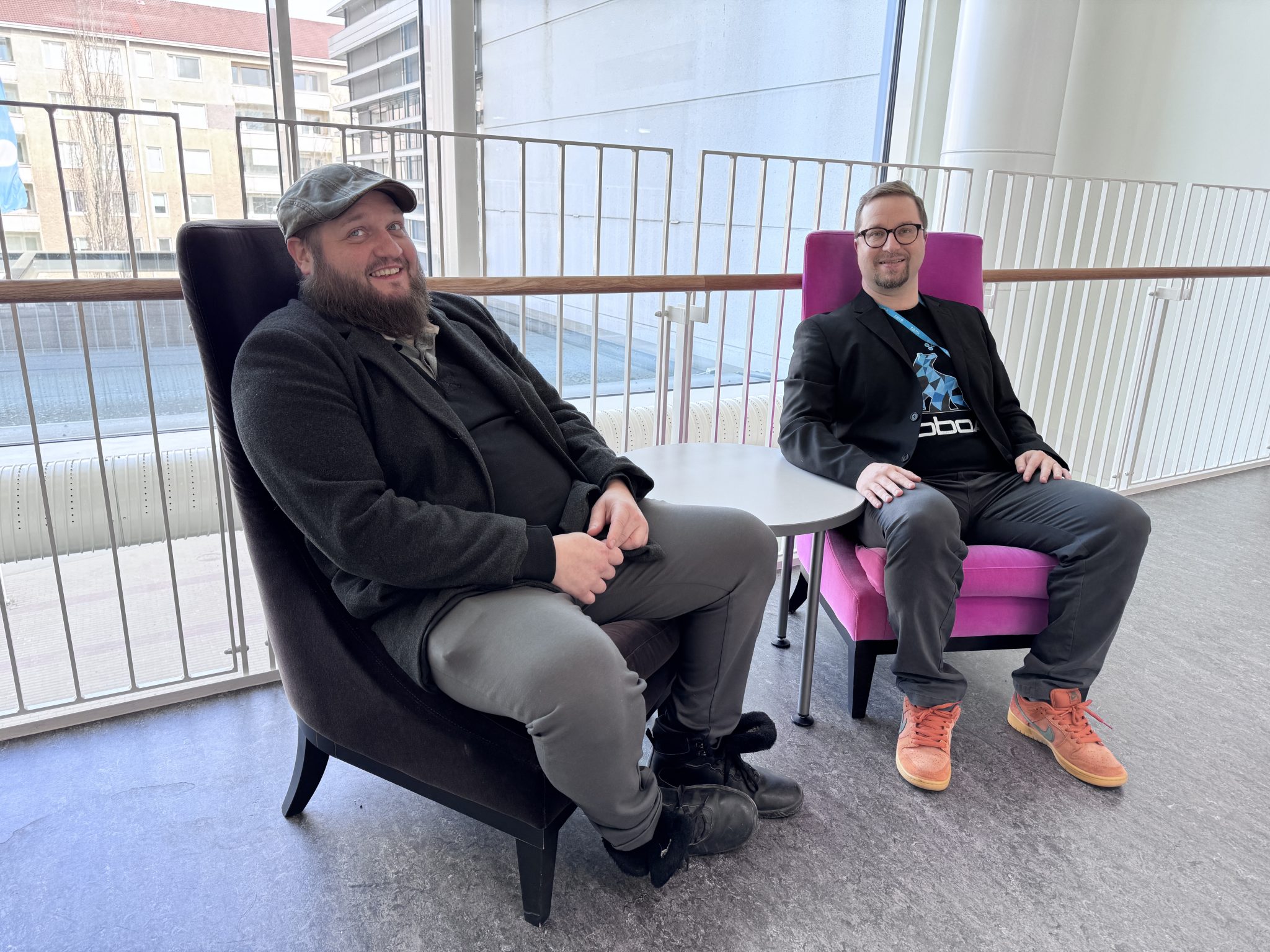 Kaksi miestä istuvat SAMKissa nojatuoleissa. Toinen istuu mustassa ja toinen pinkissä nojatuolissa.