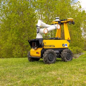 Keltainen mobiilirobotti seisoo rinteessä, taustalla vihertävää luontoa