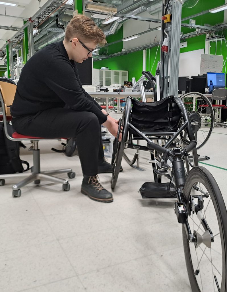 Person adjusts a racing chair in a laboratory.