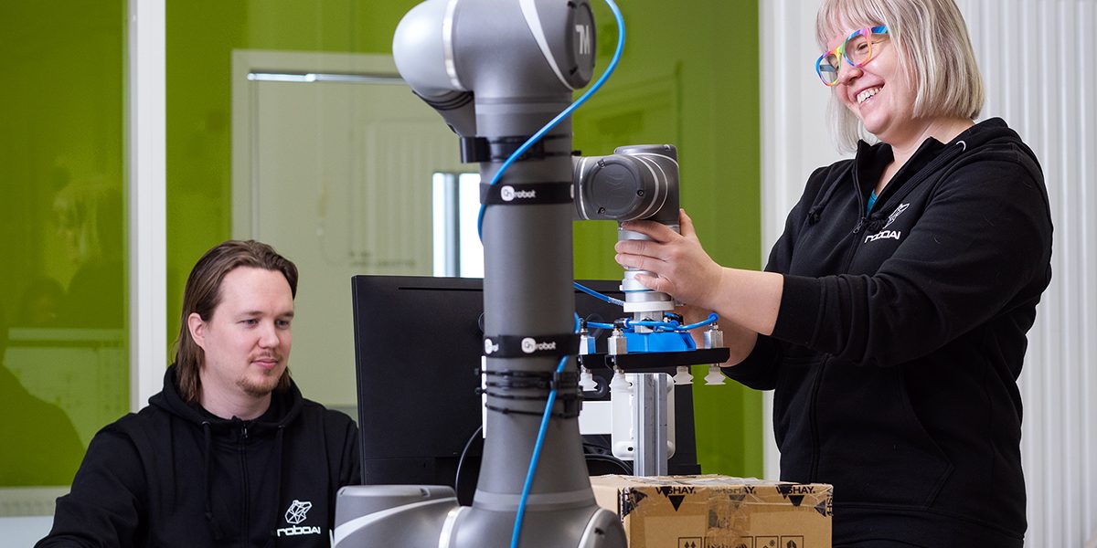 Kaksi opiskelijaa työskentelevät robotin ääressä