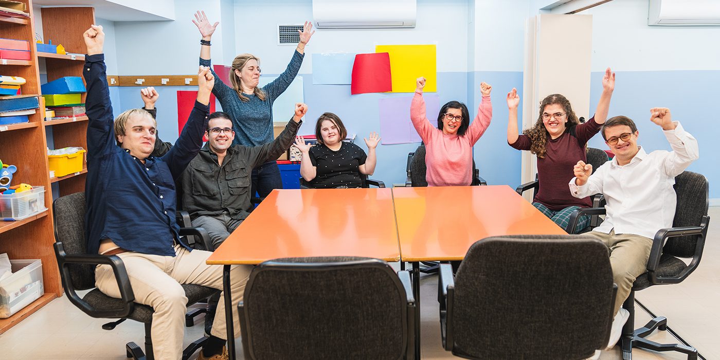 Pöydän ympärillä on erilaisia ihmisiä.