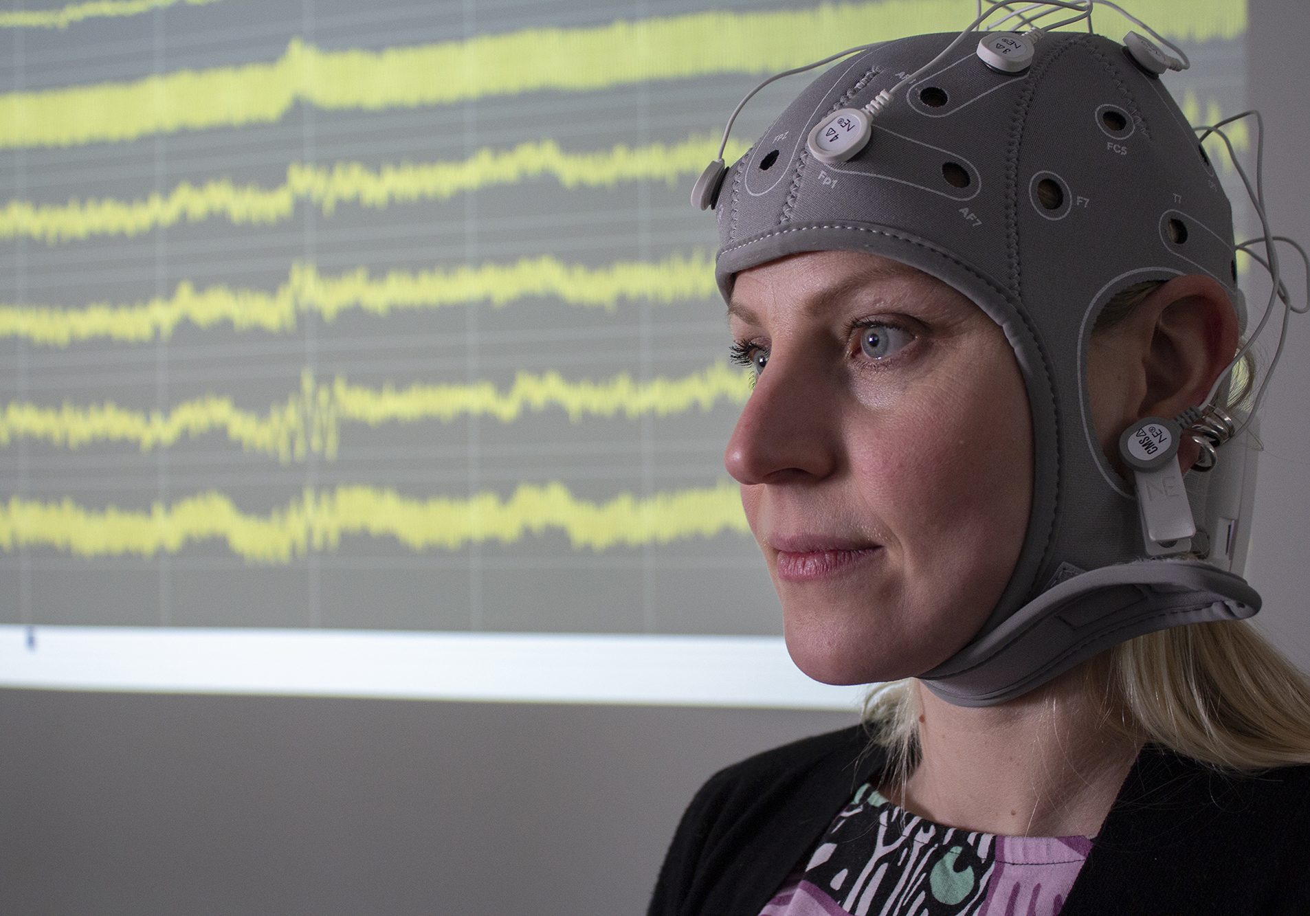 Closeup of a woman with a EEG hat on.