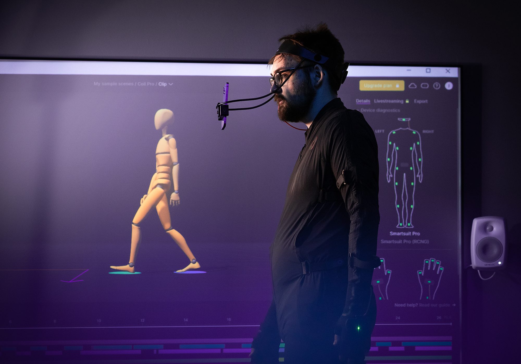 RoboAI Tutkimus Ja Tuotekehityskeskus The male subject is wearing a mocap suit with a mobile phone holder on his head and a human figure in the same pose on the wall behind him.